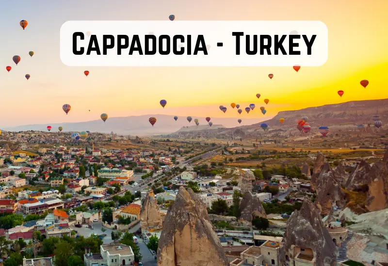 Traveller working from a scenic Cappadocia spot with hot air balloons in background.